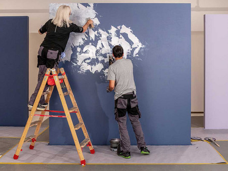 Maler und Malerin tragen zwei Farbtöne nass-in-nass auf und erzeugen durch leichte Vermischung der Farbnuancen einen homogenen Farbverlauf